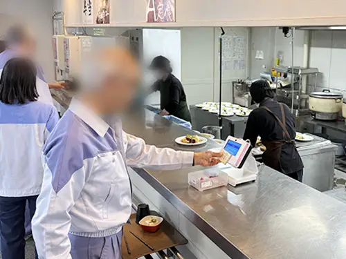 PDC-310に社員証などICカードをかざして食堂を利用する様子1