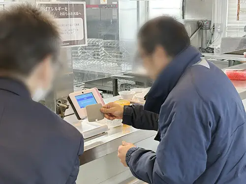 ICカードをかざして食堂を利用する様子。給与システムと連動し天引き対応なども可能です。