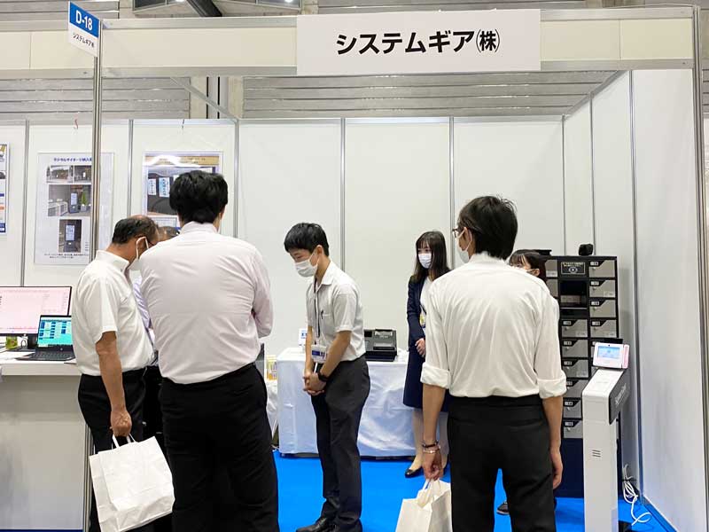 マルチ決済に対応したカウンター設置可能卓上KIOSK端末や業界最小クラスの多機能KIOSKを説明している様子